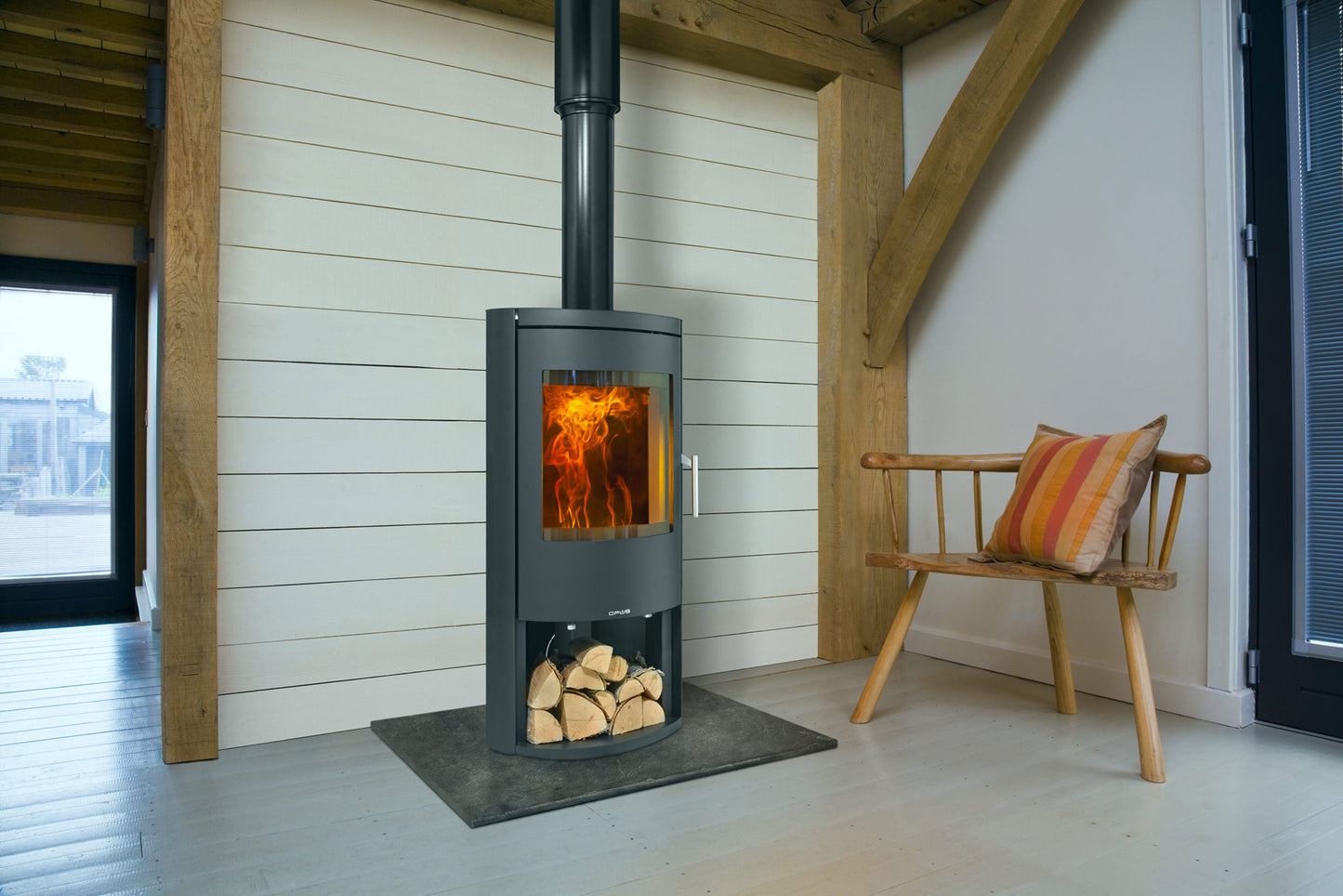 Opus Wood-burning stove in a modern room with wooden beams and a bench.
