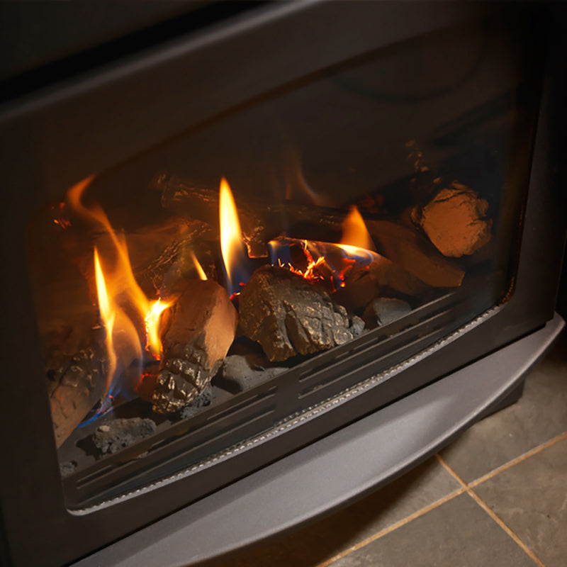 A close-up of a gas fireplace with glowing flames and realistic log props visible through a dark glass front.