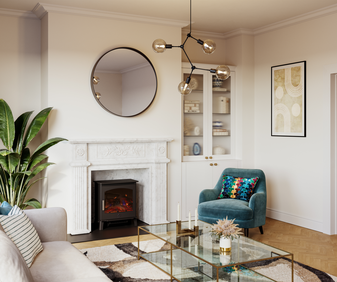 A styled living room interior featuring a white fireplace with a black electric insert, a round black-framed mirror, a teal velvet armchair with a colorful patterned pillow, a glass coffee table, and a large potted plant.