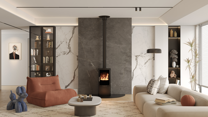 ACR Neo XC. A modern living room featuring a black wood-burning stove with a tall black chimney pipe set against a large dark gray stone wall. The room is styled with a terracotta armchair, a cream sofa, a round coffee table, and marble-patterned accent walls.
