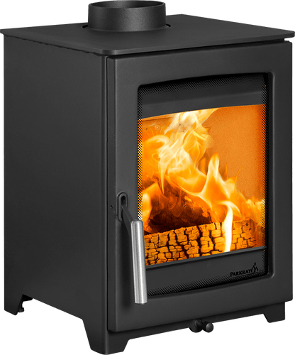 A black Pürsät wood-burning stove with a visible fire inside, shown on a plain white background. The stove features a front glass window with a metal mesh screen, a silver handle, and a circular chimney pipe on top.