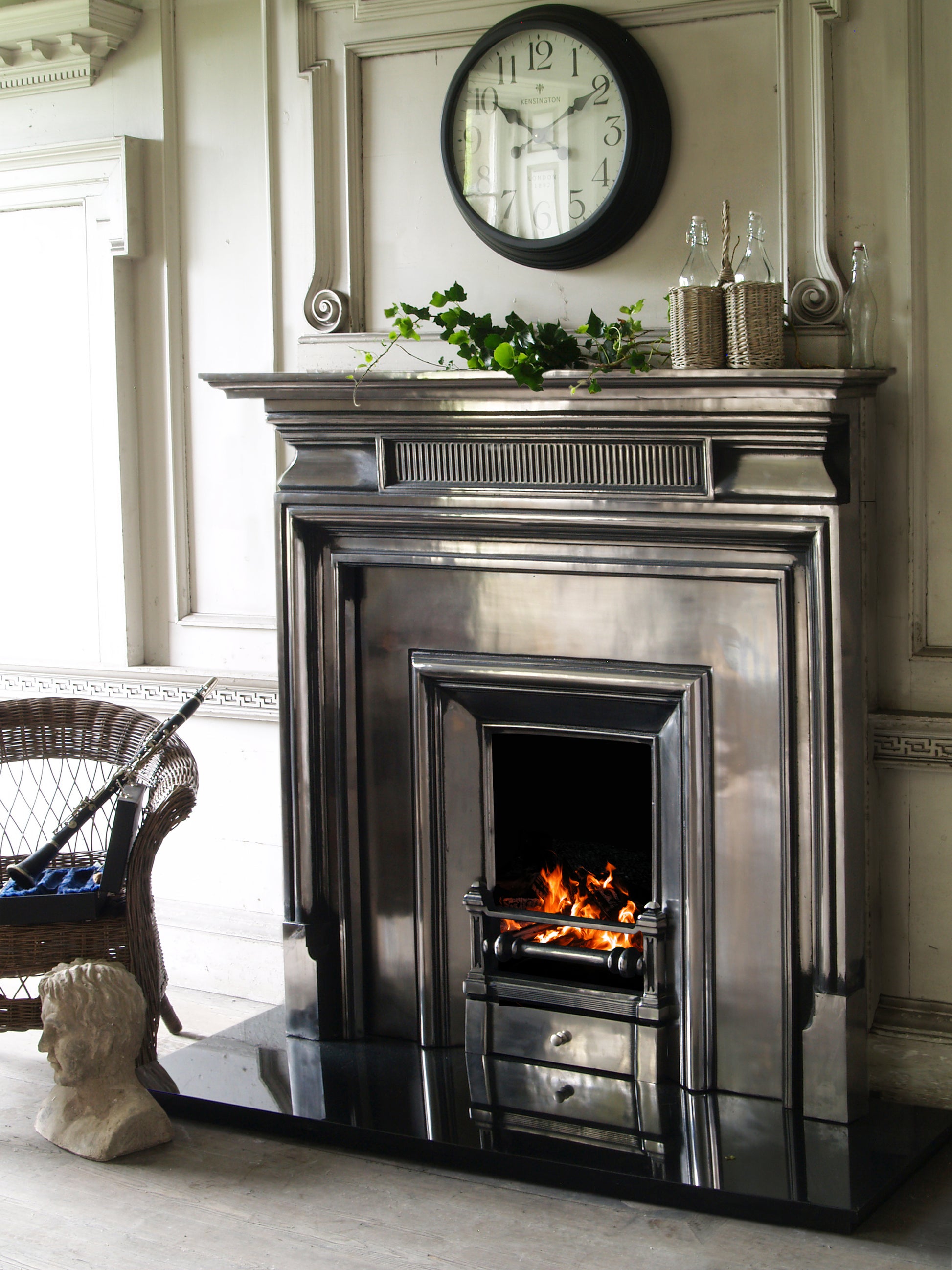 Carron Belgrave Decorative fireplace with a mantel, clock, and decorative items in a room.