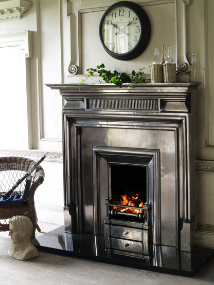 Carron Belgrave Decorative fireplace with a mantel, clock, and decorative items in a room.