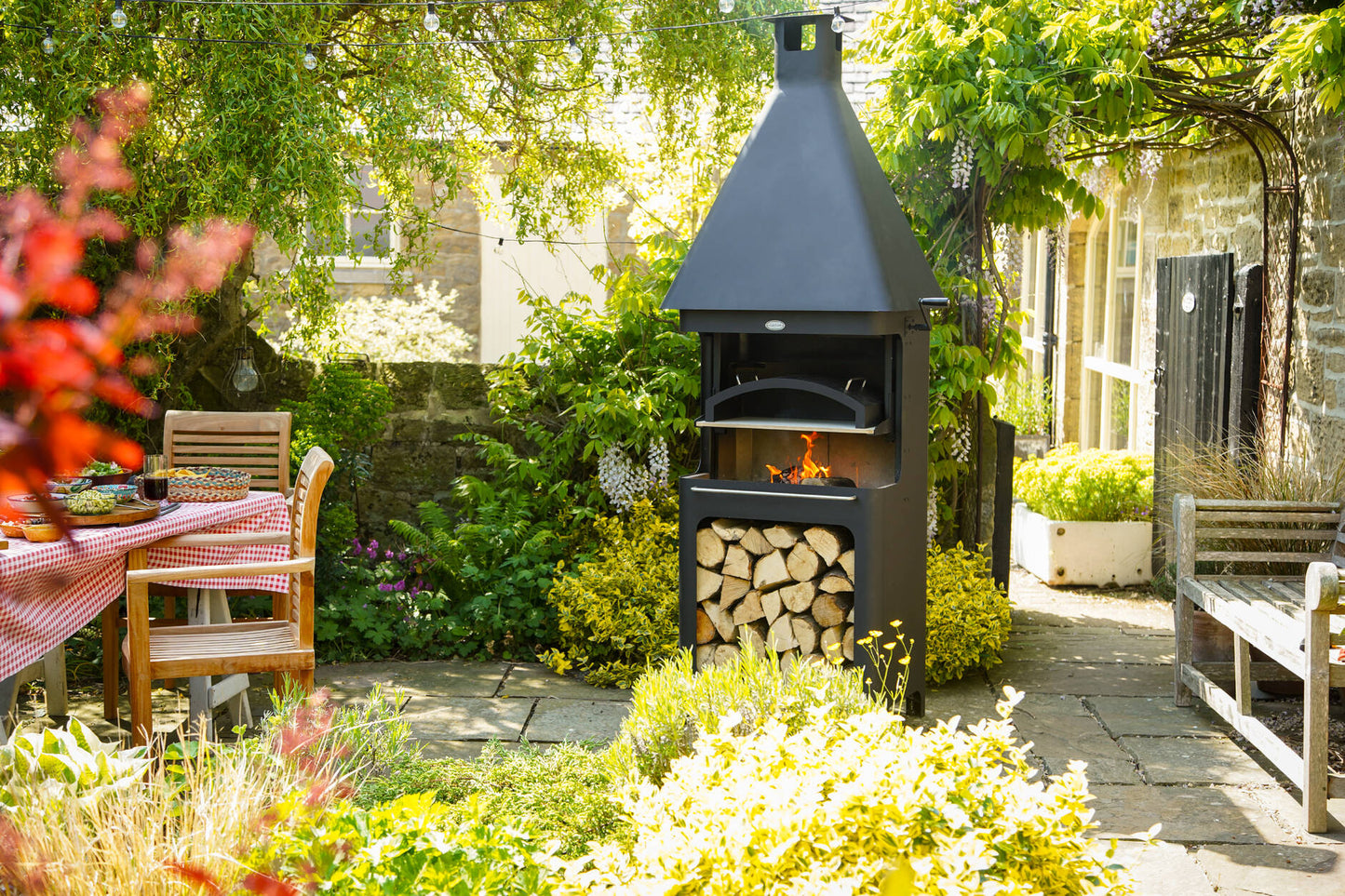 Carron Bellmount BBQ Fireplace Outdoor barbecue grill with firewood storage in a garden setting