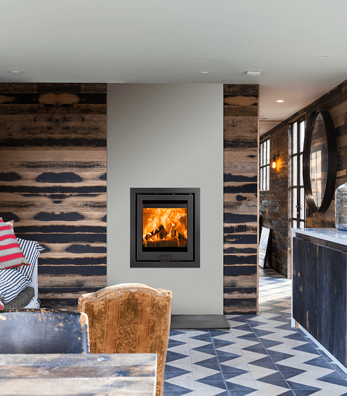 Di Lusso R5 Eco Inset in a kitchen setting with blue floor tiles, wooden walls and rustic chairs.