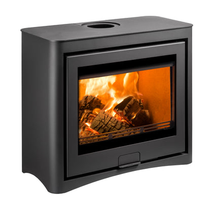 Side view of a modern black freestanding square wood-burning fireplace with a glass viewing window showing bright orange and yellow flames, and an open lower shelf holding stacked firewood logs, isolated on a white background.