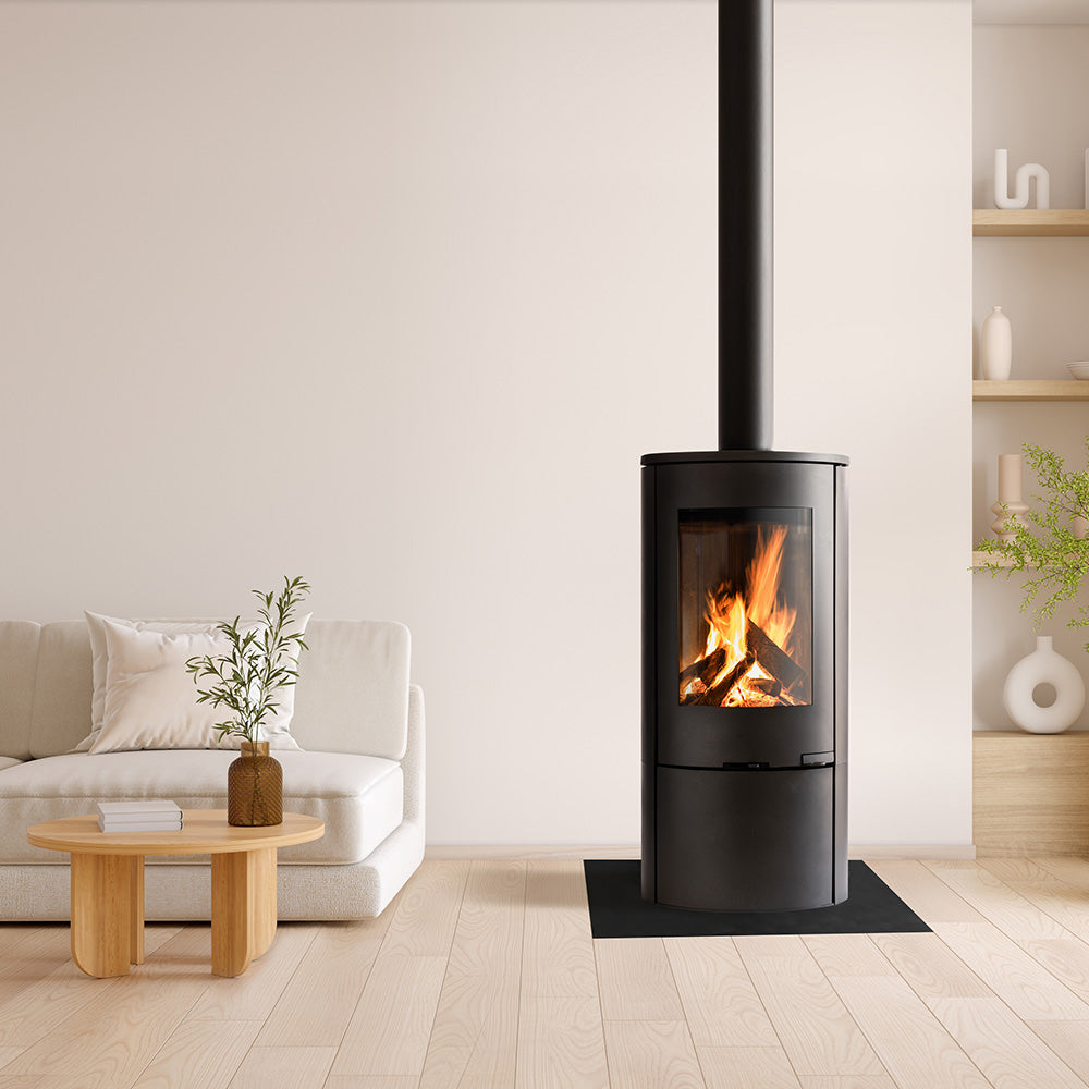 Explorer C5 310 Logstore black freestanding stove in a living room with a white sofa and wooden coffee table.