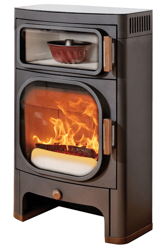 A freestanding wood-burning stove with a dark brown metal body, glass doors, copper-toned handles, and visible flames with glowing embers inside. A small decorative bowl sits in the upper shelf compartment.