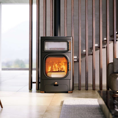 Modern wood stove in a living room with a glass door showing flames.