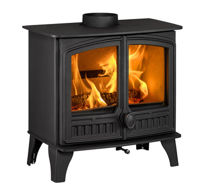 A black cast iron wood-burning stove with two glass doors showing bright orange flames and logs inside, isolated on a white background.