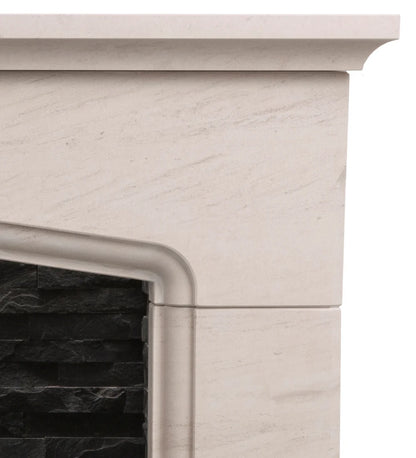 Close-up of a cream-colored limestone fireplace mantel and surround with a black stacked stone insert visible on the left.