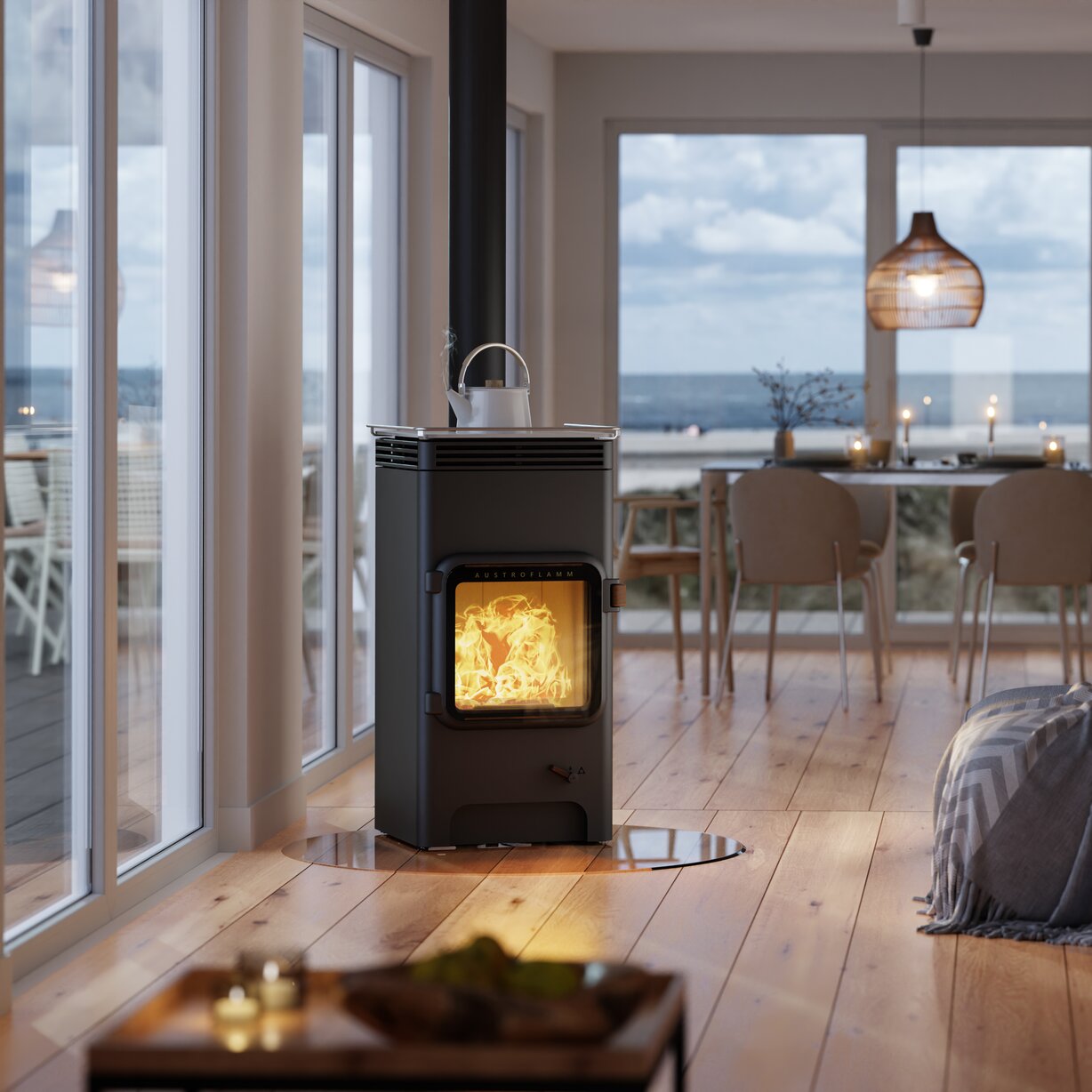 Modern living room with a wood stove and large windows overlooking the ocean.