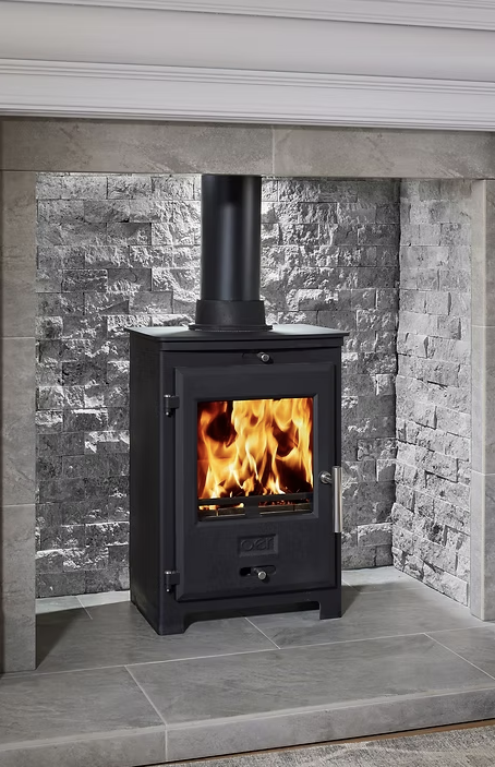 OER 5kW Multi Fuel Stove. Black wood stove with flames inside, set against a stone wall.