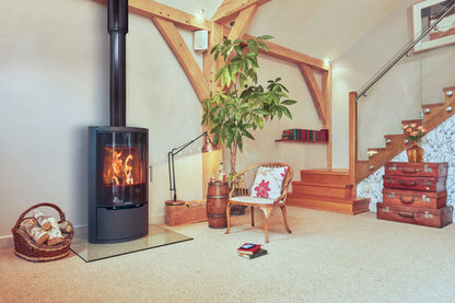 Living room with a Opus wood stove, chair, and decorative items.