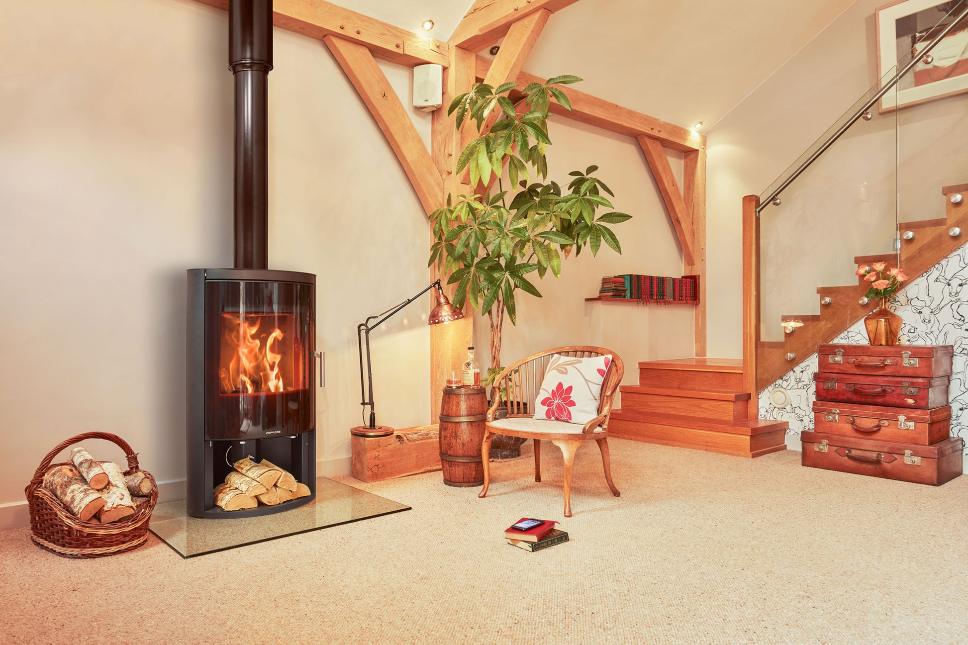 Living room with a Opus GLS wood stove, chair, and decorative items.