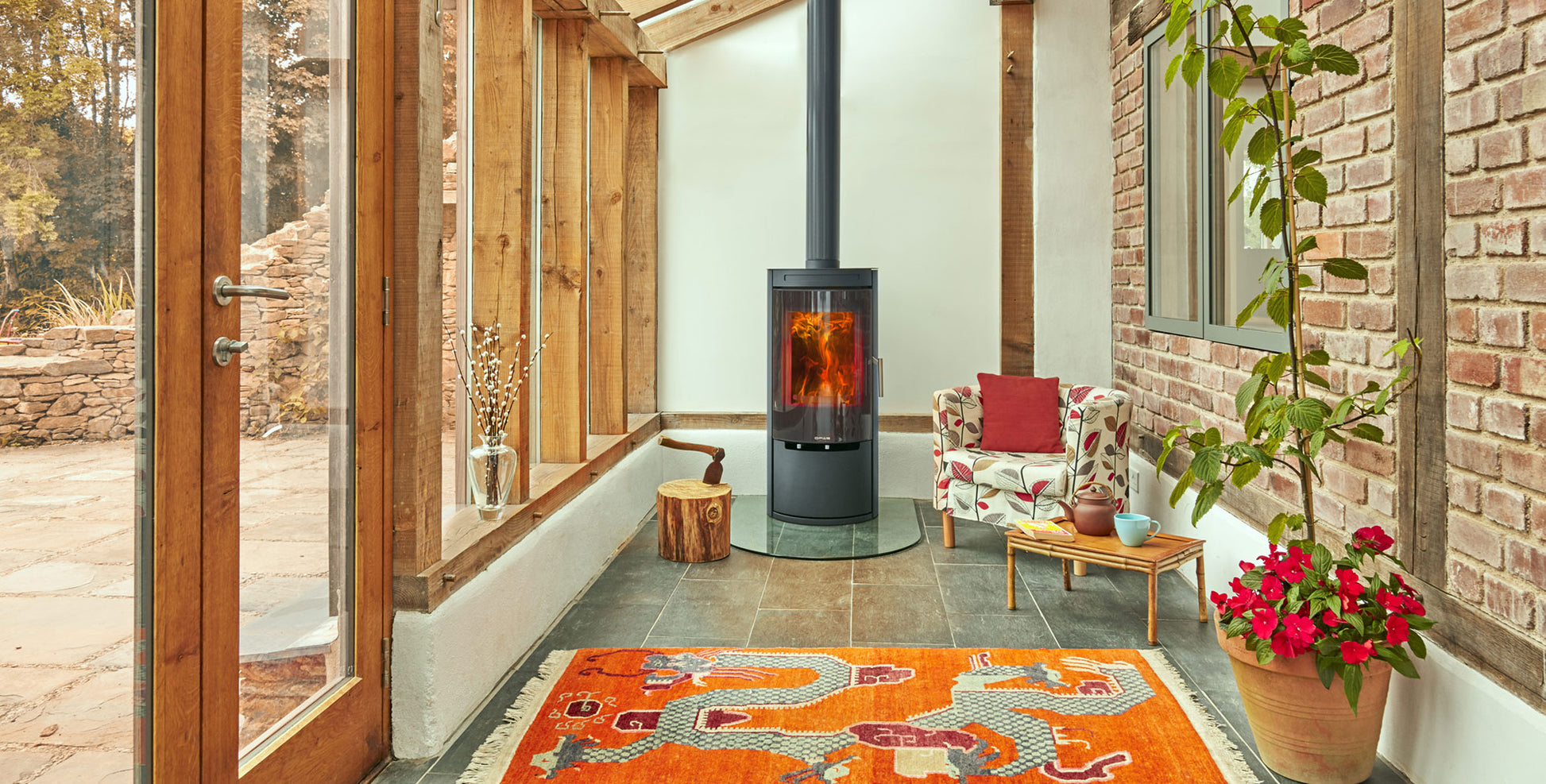 Opus fire by a  colorful rug, and decorative elements.