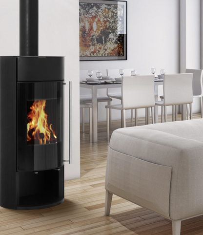 Modern Opus Calypso black freestanding fireplace in a living room with a dining area in the background.
