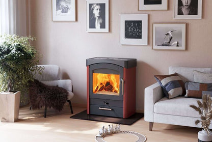 A modern wood-burning fireplace with a black top and frame, set in a cozy living room next to a light gray sofa and framed wall art.