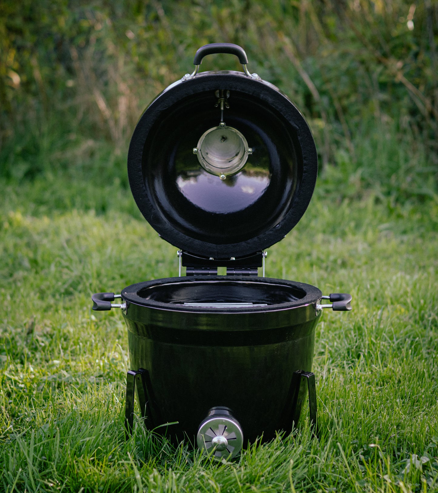 Salamanda Little Cayuga Black portable toilet with open lid on grass