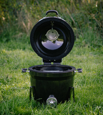 Salamanda Little Cayuga Black portable toilet with open lid on grass