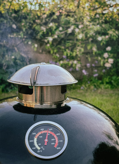 Salamanda Little Cayuga  Smoker hood with thermometer on a grill against a natural background