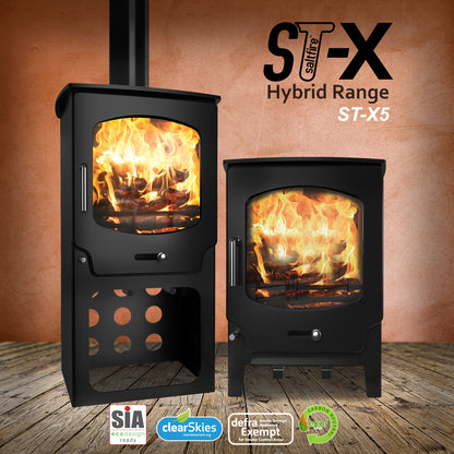 Two Saltfire ST-X5 hybrid range cook stoves with flames inside, on a wooden floor against an orange wall.