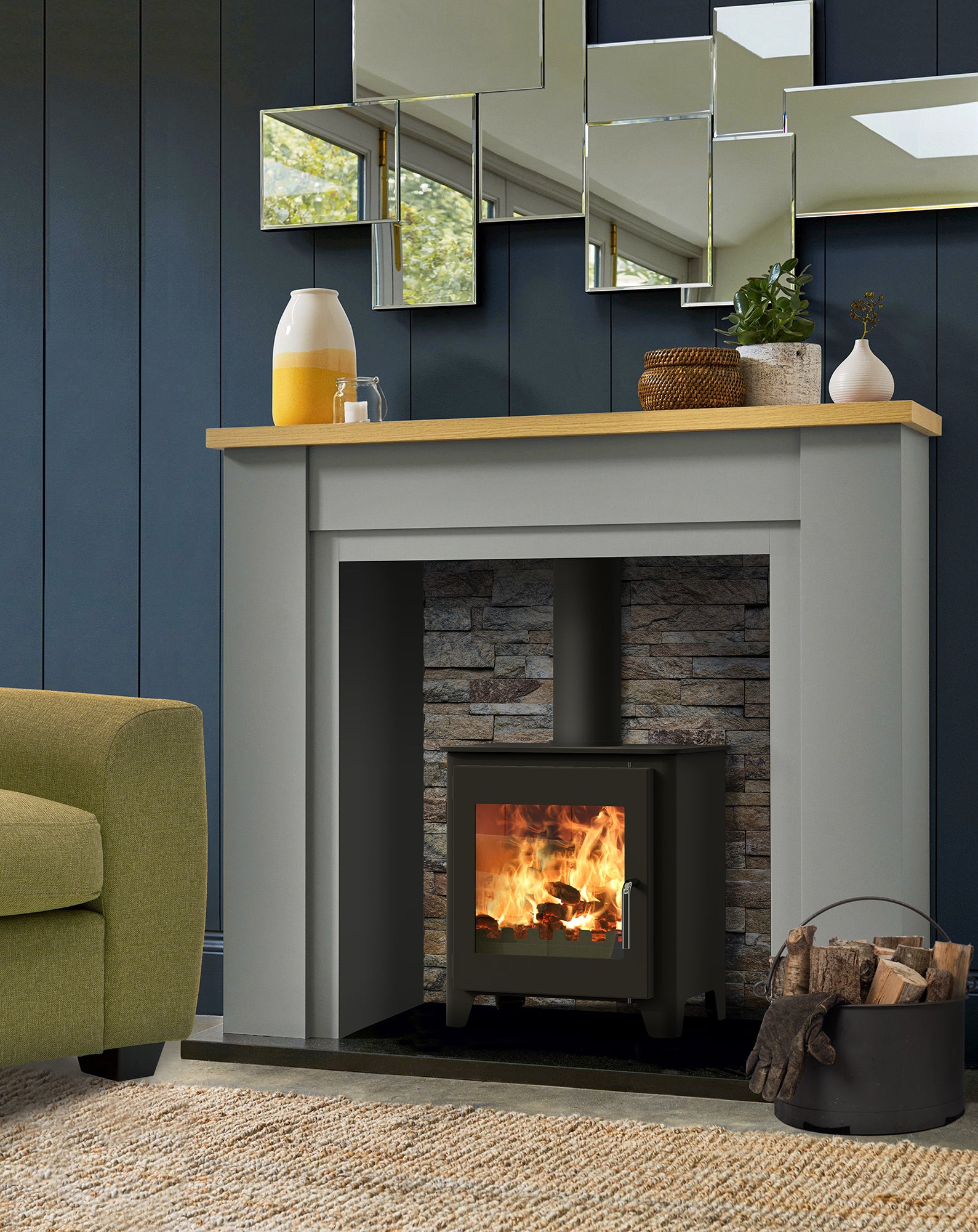 Modern Saltfire ST1 fireplace with wooden mantel against a blue wall, featuring a green armchair.