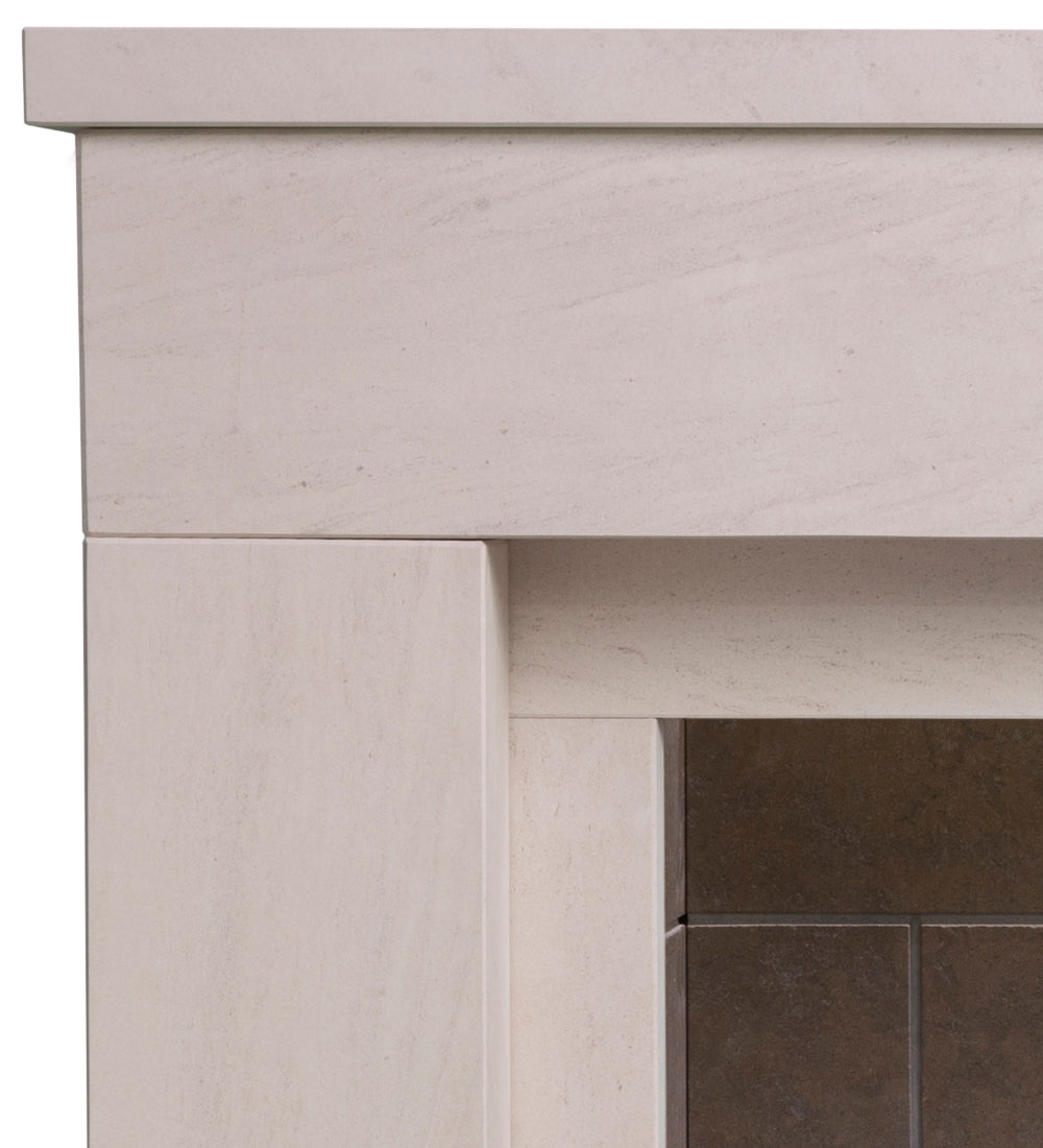 Close-up of a light beige stone fireplace mantel and surround with a dark brown tiled hearth visible in the lower right.