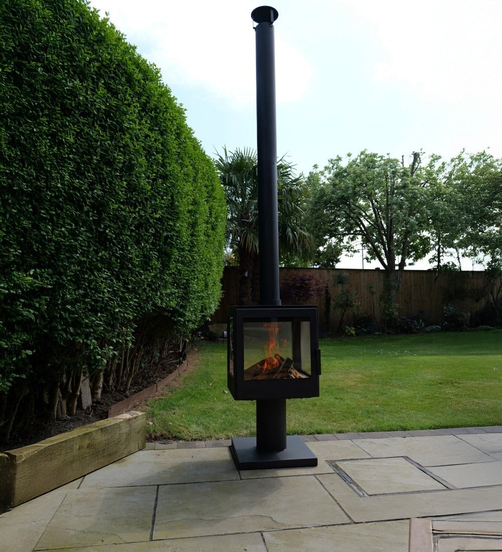 Outdoor patio heater on a paved area with greenery in the background